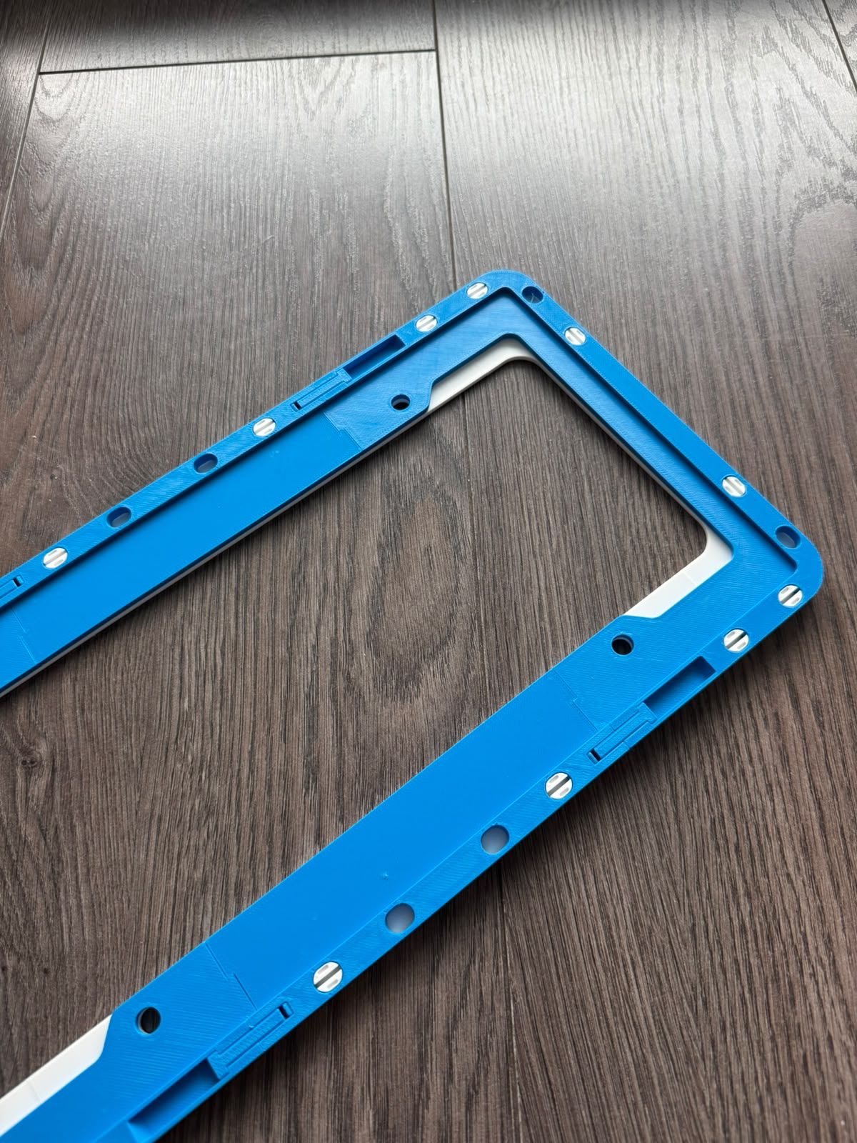 Back of the Family Mart license plate frame showing the mounting face and bolt holes