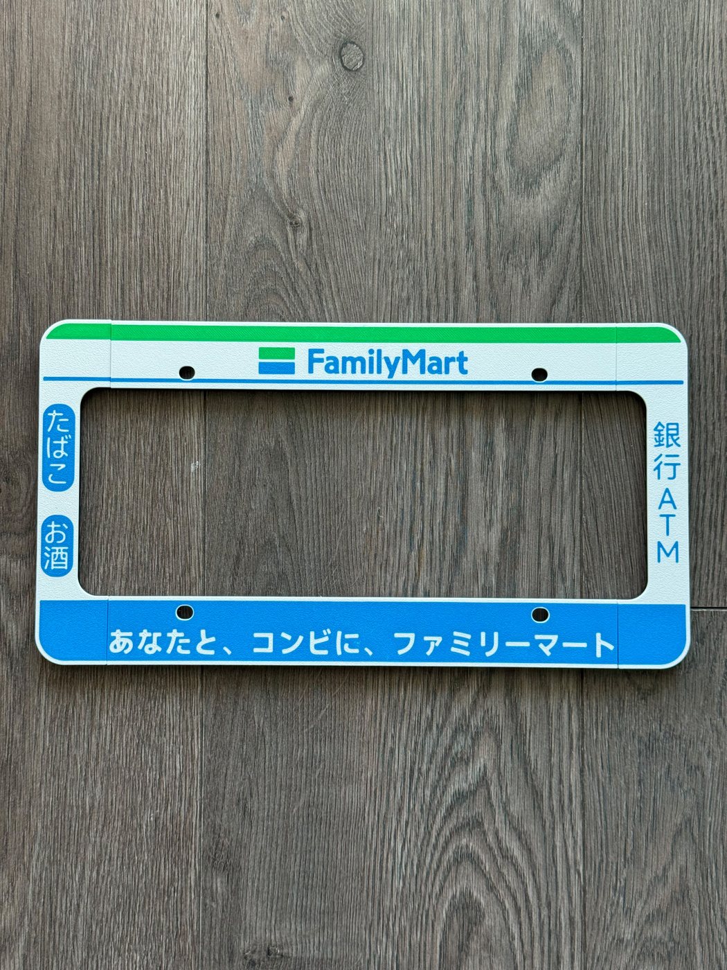 Front face of the FamilyMart 3D-printed licence plate frame in konbini green and blue